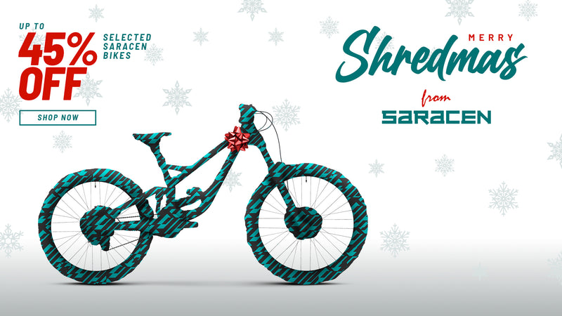 Saracen bike with festive design on a white background with snowflakes, featuring a Christmas sale promotion.