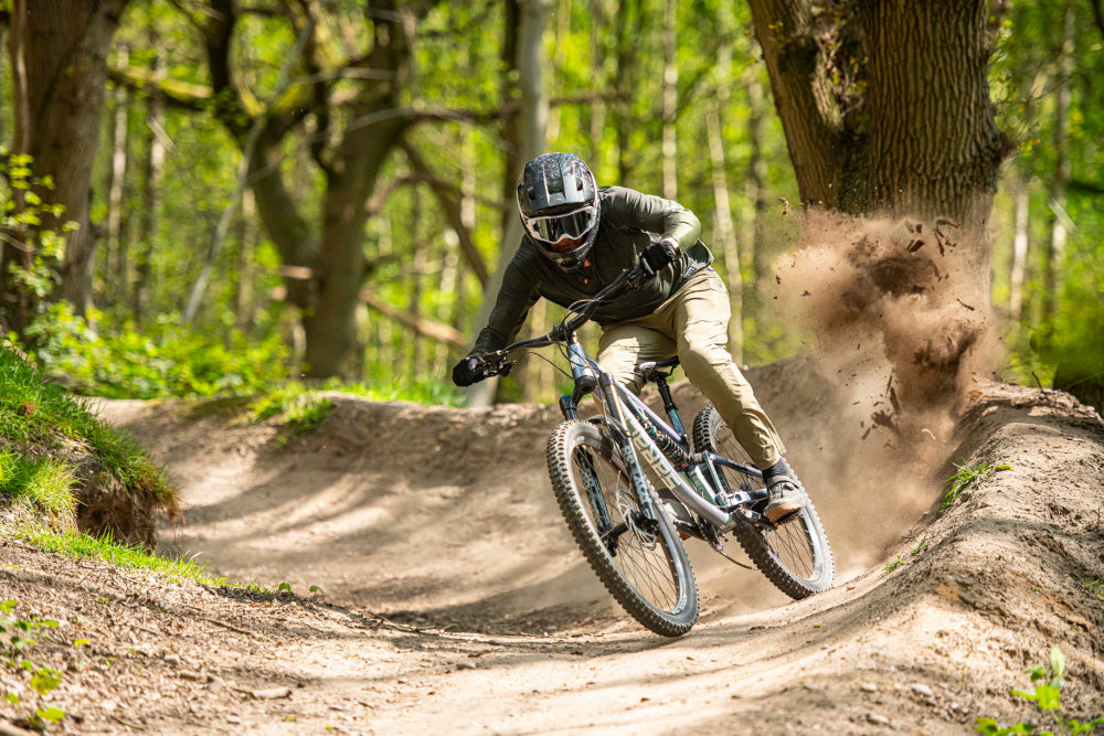 Person riding a mountain bike on a dirt trail in a forest