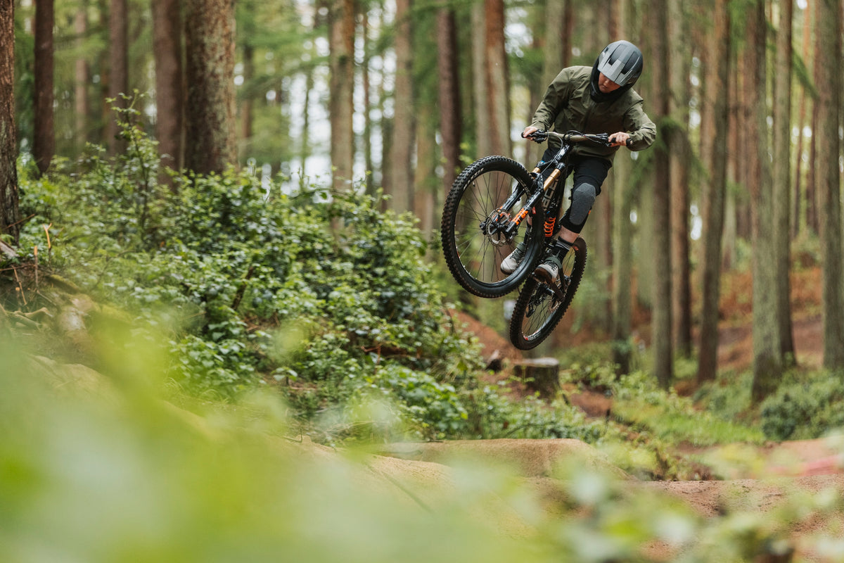 Person riding a mountain bike through a forest