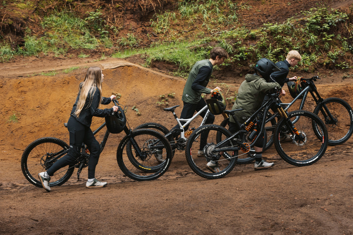 Group of people with mountain bikes on a dirt trail