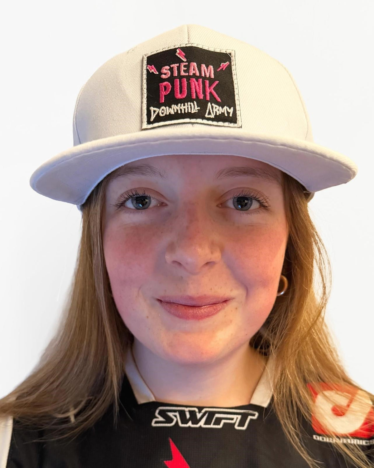 Person wearing a white cap with a 'Steam Punk' patch on a white background