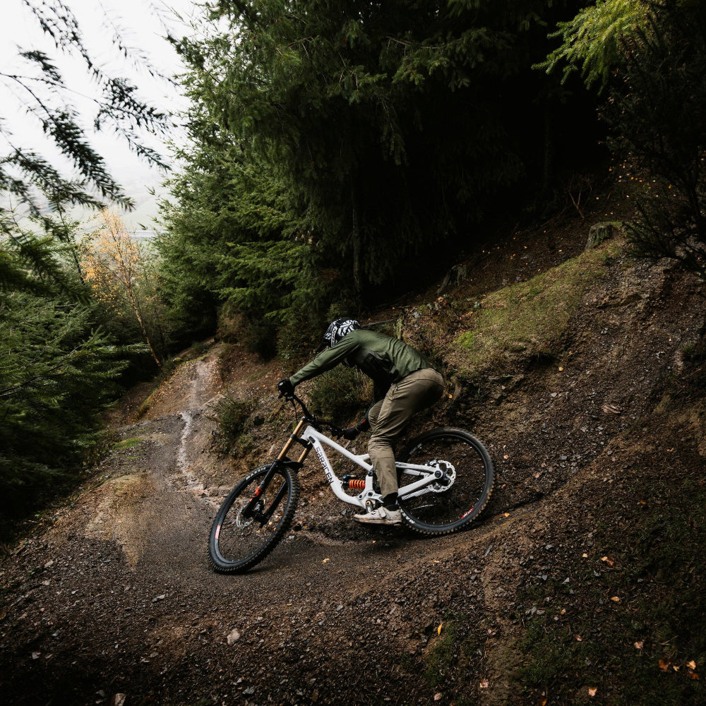 Person riding a mountain bike on a rocky trail in a forest