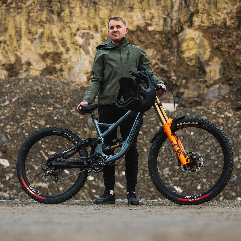 Man holding a mountain bike against a rocky background
