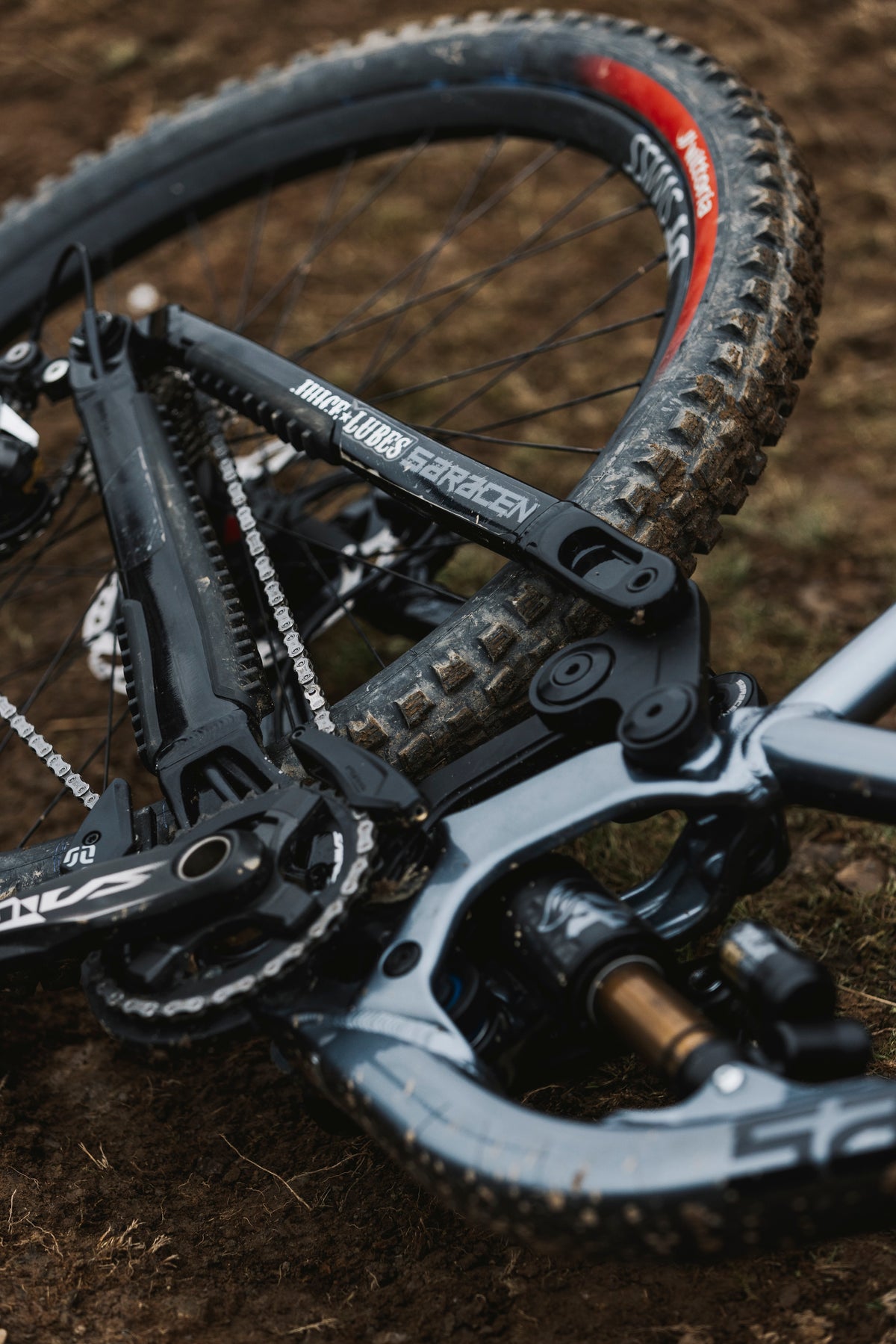 Close-up of a bicycle's suspension fork and wheel on a dirt surface