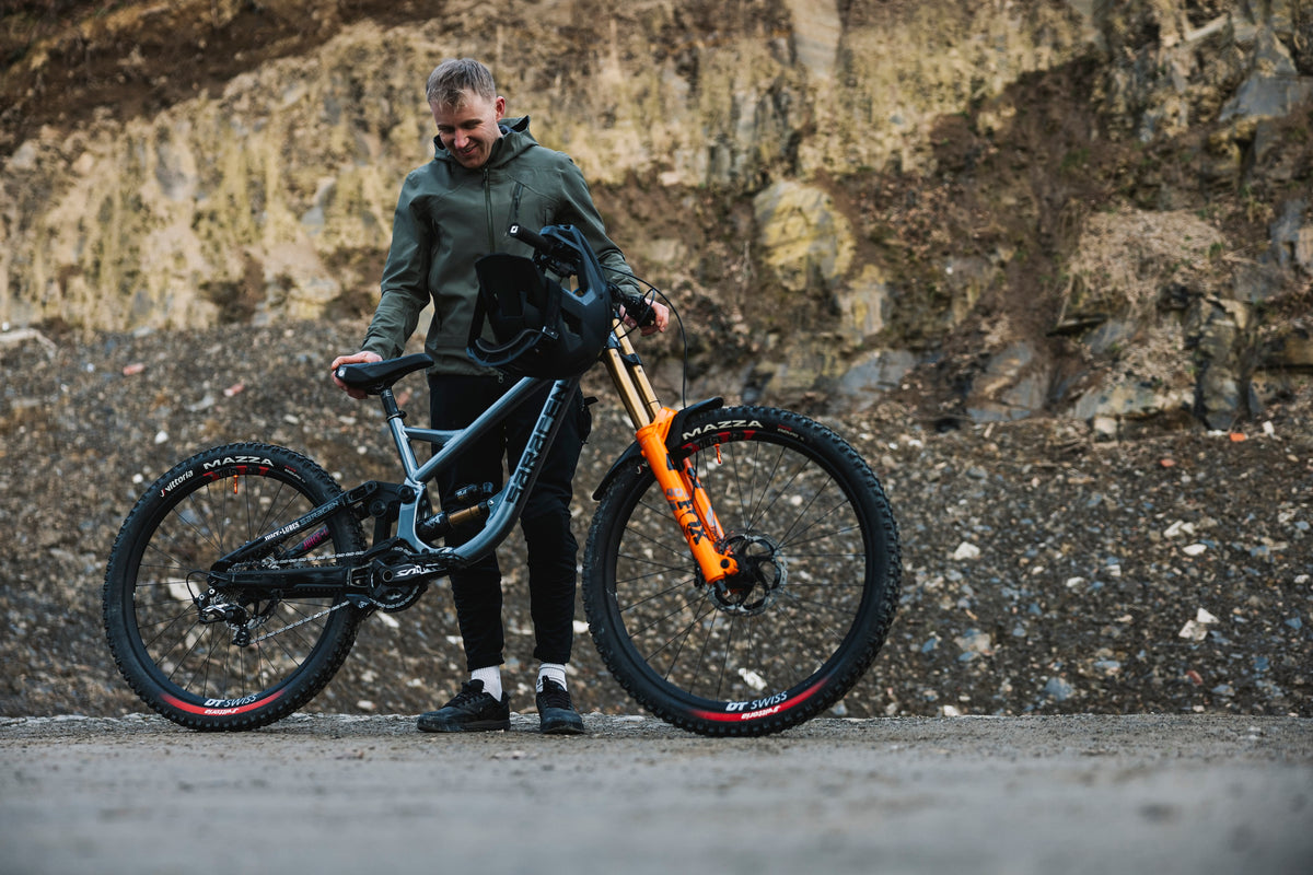 Person holding a mountain bike against a rocky background