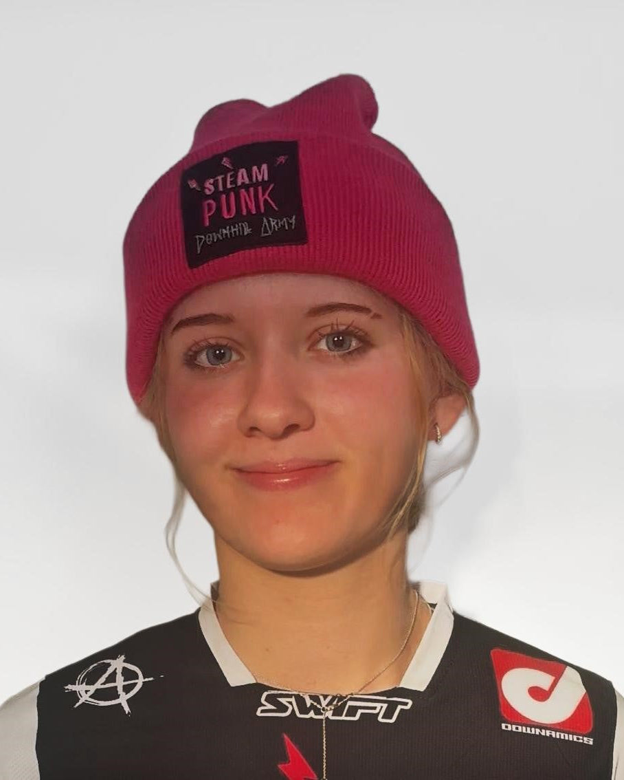 Person wearing a pink beanie with text and a black and white sports outfit with logos.