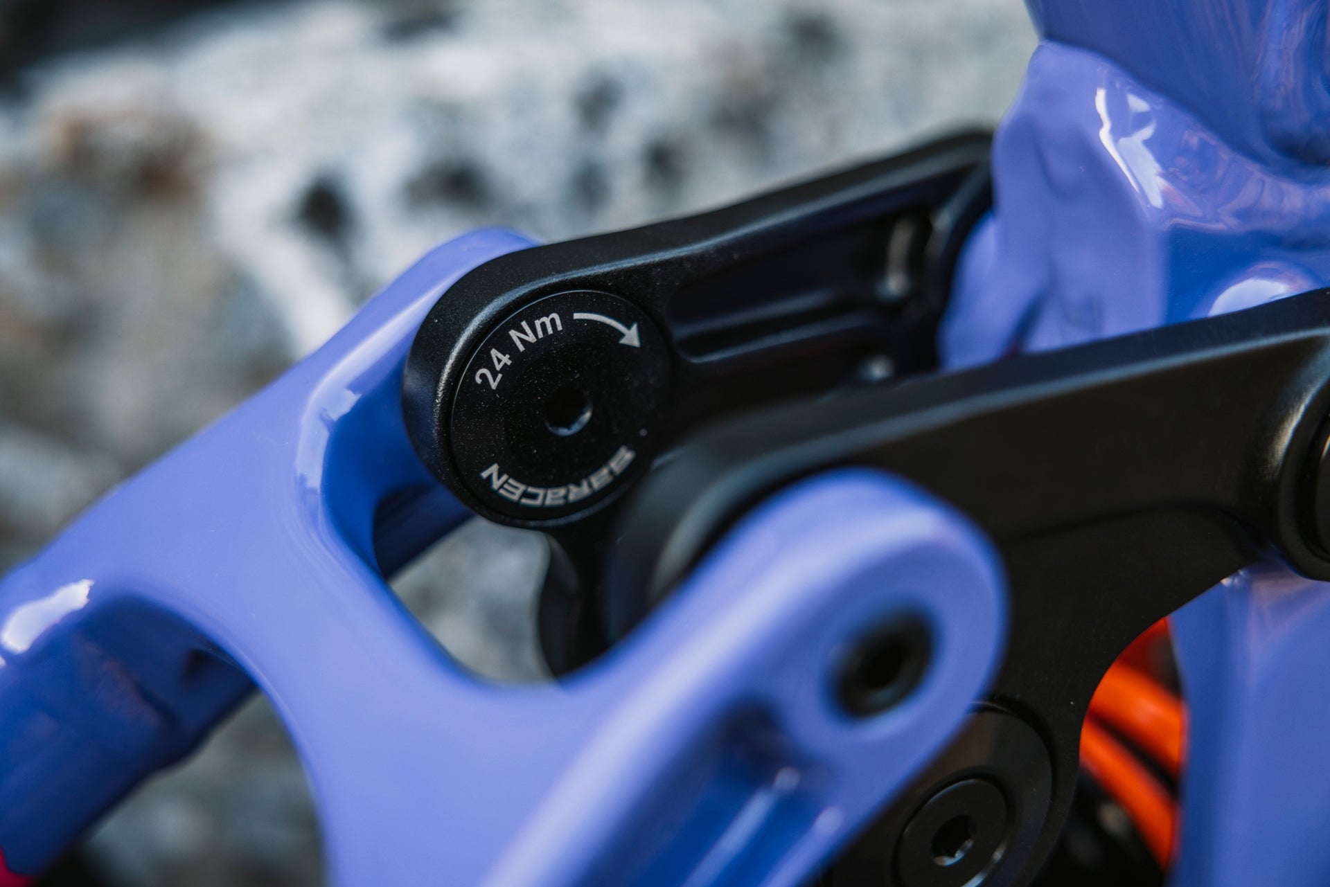 Close-up of a bicycle mechanism with a blue frame and black component labeled '24 Nm'.