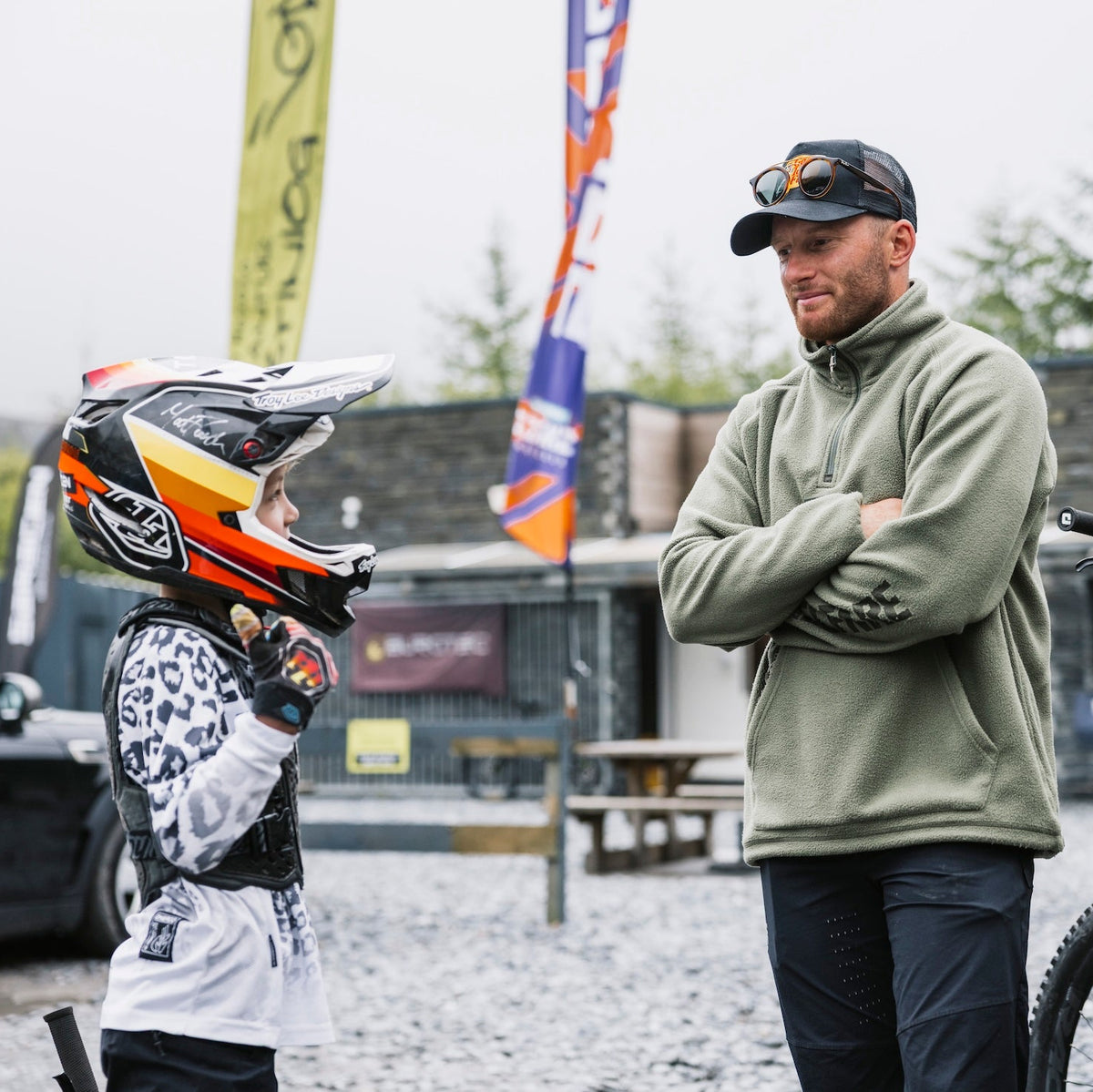 Two people with a helmet and bike in an outdoor setting