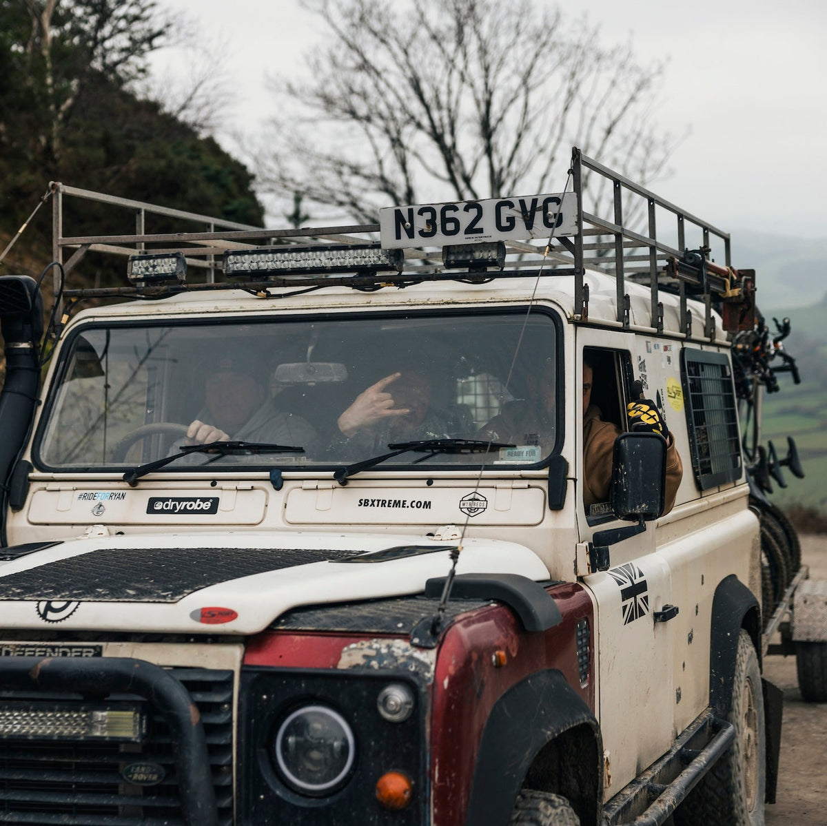 White off-road vehicle with roof rack on a rural road