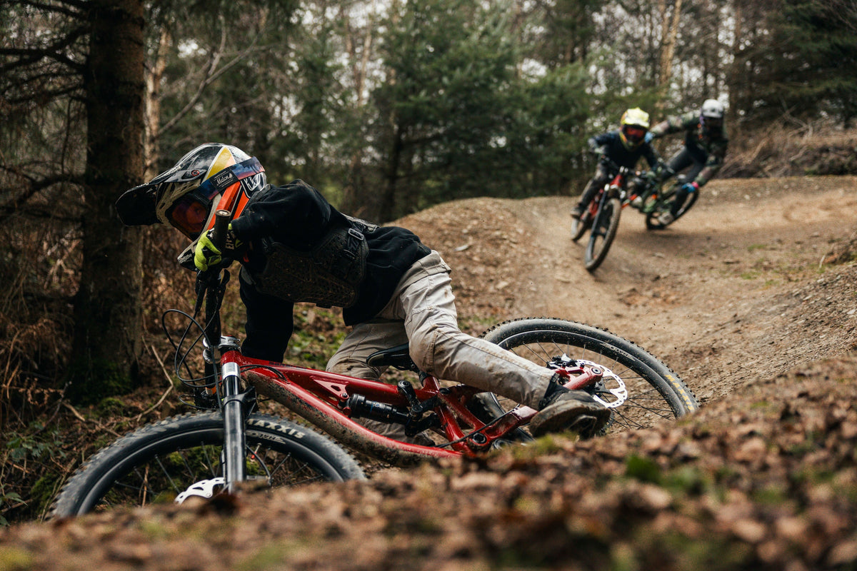 Biker falling off a bike on a dirt trail in a forest