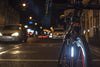 Bicycle on a city street at night with blurred lights in the background