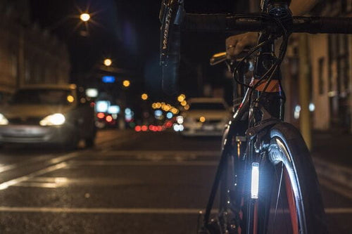 Bicycle on a city street at night with blurred lights in the background