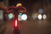 Bicycle tail light with blurred lights in the background