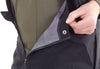 Close-up of a person adjusting the collar of a dark jacket with a green inner lining.