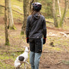 Person in outdoor gear with a dog in a forest setting