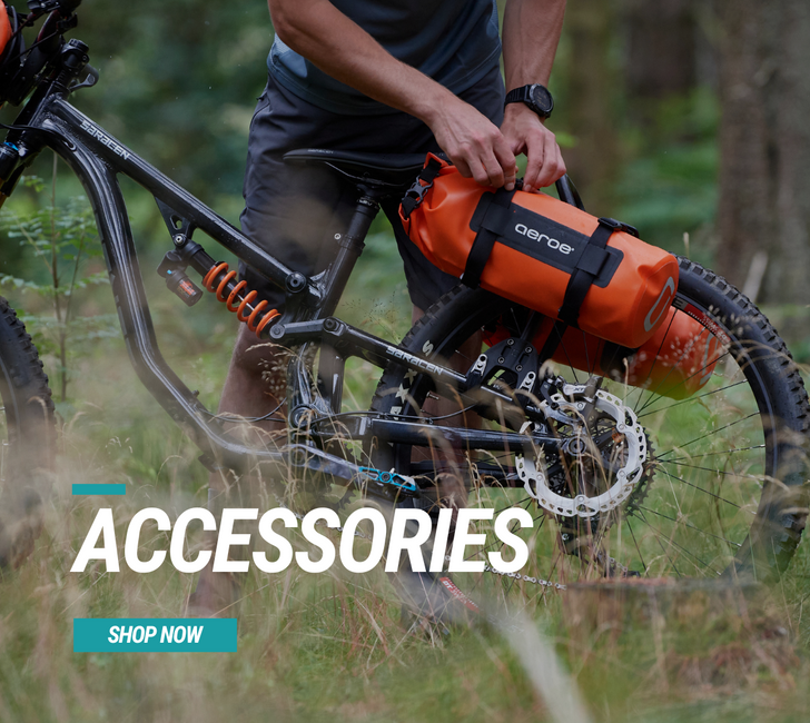 Person on a bike with an orange AERO3 bag, surrounded by nature.