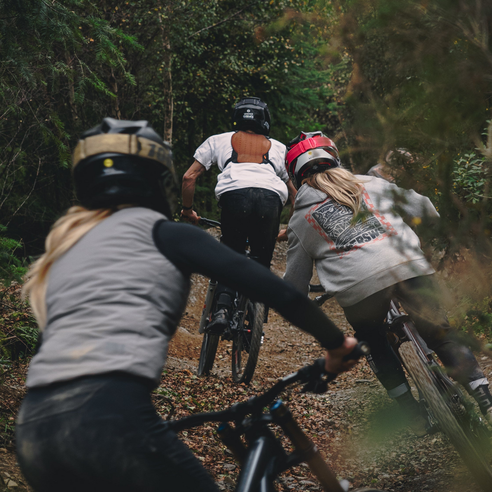 Three people riding bicycles on a forest trail